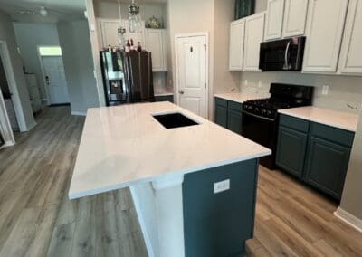kitchen island with white quartz and faint veining countertop and generous counter overhang for kitchen dining