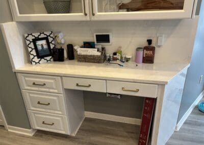 desk with white quartz countertop and matching white quartz waterfall side and high backsplash